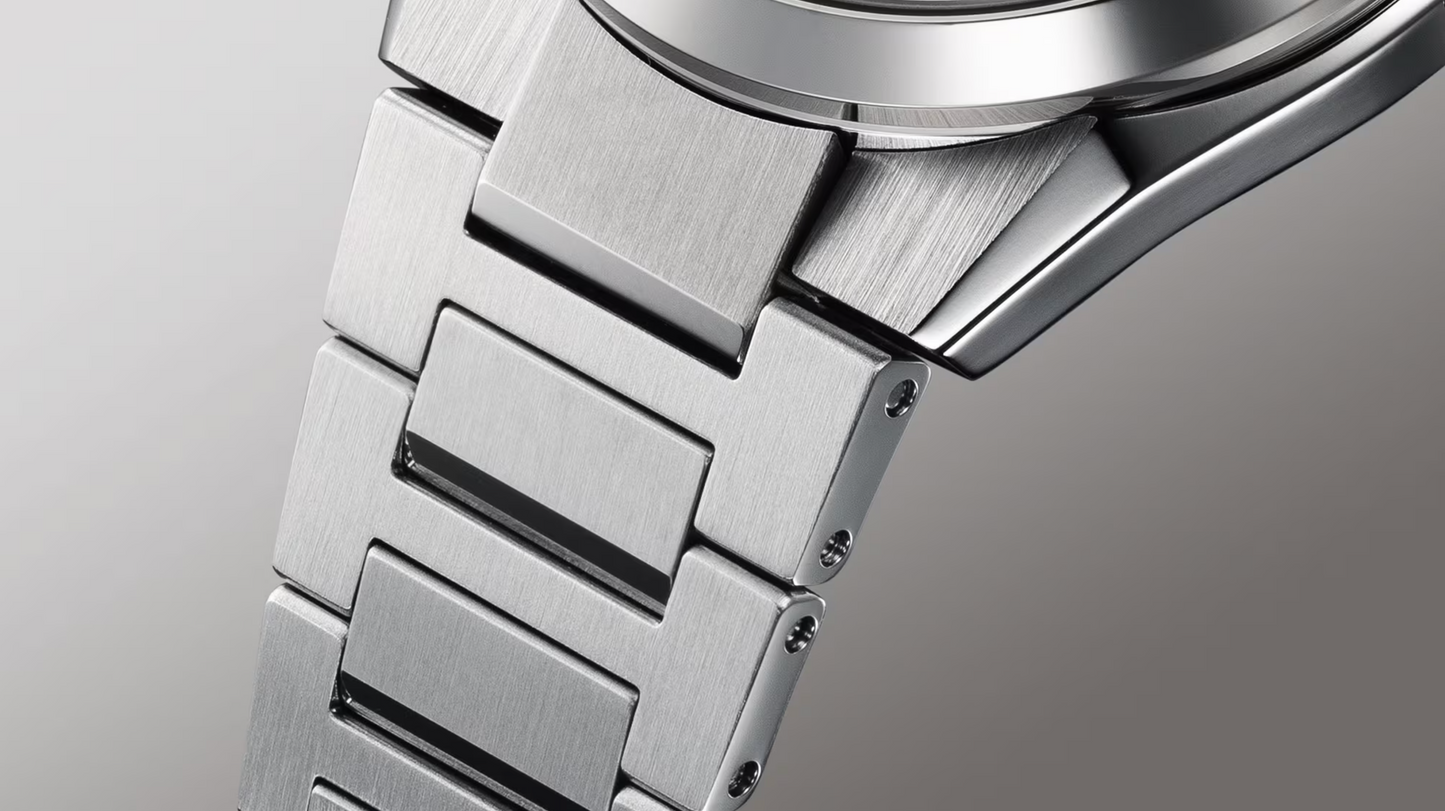 Close-up of a silver watch band on a light gray background